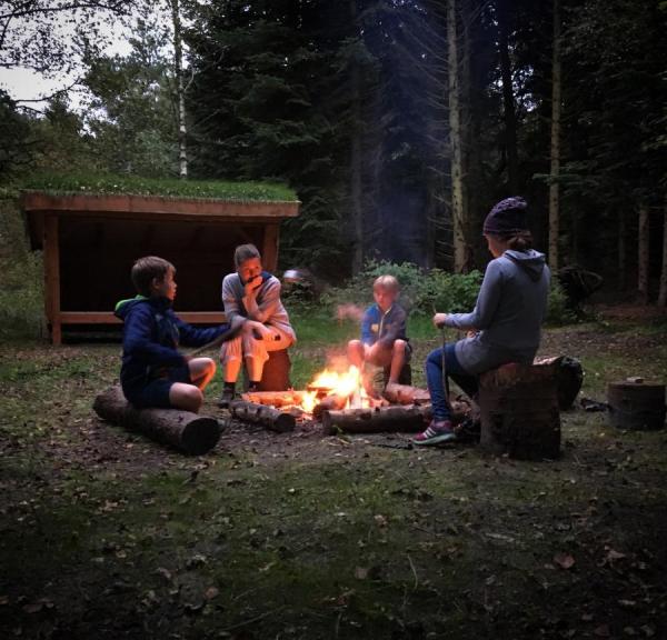 Familie hygge ved bålsted og shelter